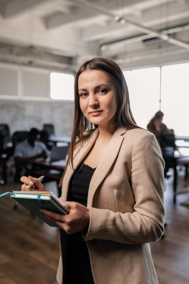 A Woman Holding a Notebook and a Pen